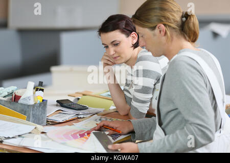 Painter with apprentice showing colour sample for next site Stock Photo