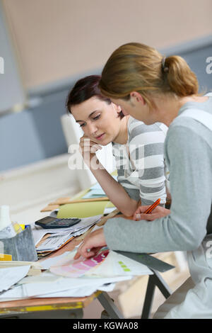 Painter with apprentice showing colour sample for next site Stock Photo