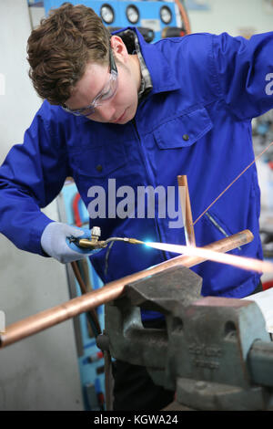 student in plumbing professional training, working on copper Stock Photo