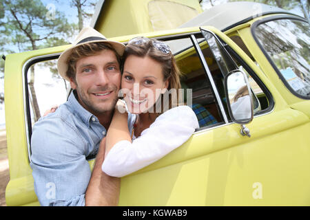 Couple standing by vintage camper van window Stock Photo