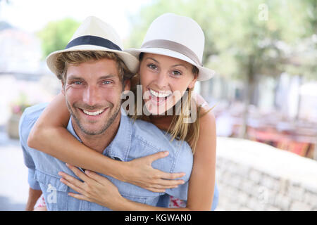 Cheerful man giving piggyback ride to girlfriend Stock Photo