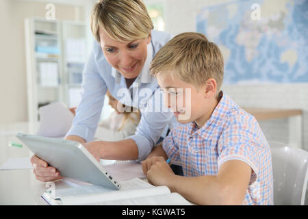 Teacher using digital tablet as educational tool in class Stock Photo
