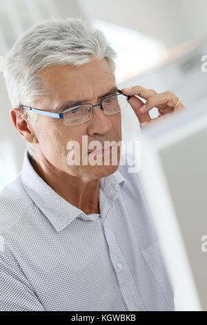 Senior man connected on desktop computer Stock Photo