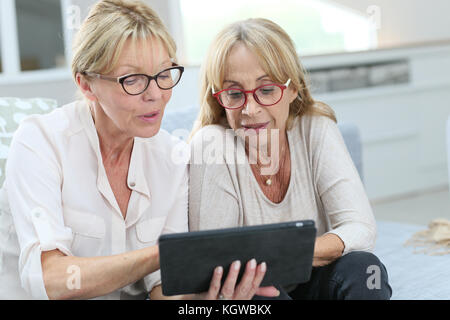 Senior women at home using digital tablet Stock Photo