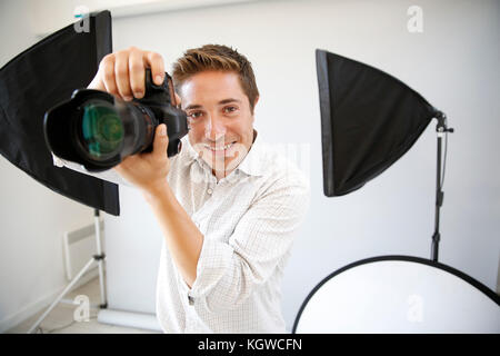 Photographer in studio with lighting equipment Stock Photo