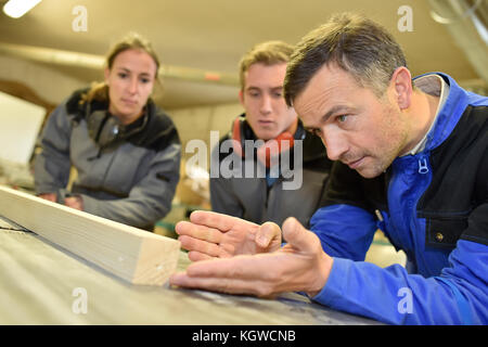 Carpenter instructor with students in workshop Stock Photo
