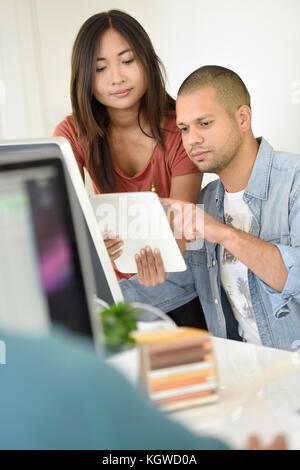 Business people in office working together on desktop Stock Photo
