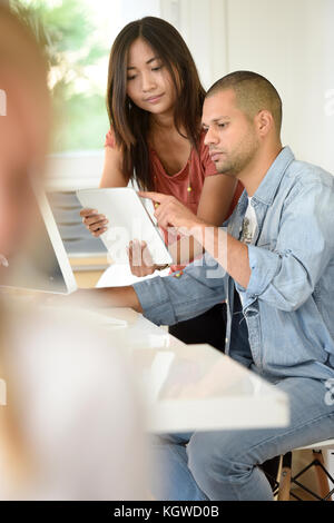 Business people in office working together on desktop Stock Photo