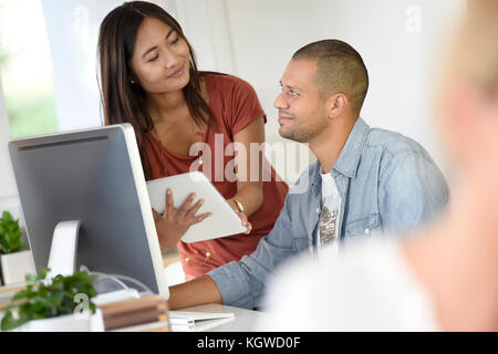 Business people in office working together on desktop Stock Photo