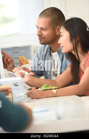 Office-workers having lunch in office in front of desktop Stock Photo