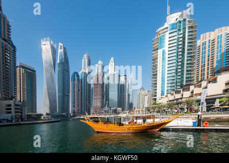 DUBAI, UAE - 31OCT2017: A dhow backed by the Iconic towers of Dubai Marina including (l-r) Cayan, Damac Heights, Marriott, Emirates Crown, Princess To Stock Photo