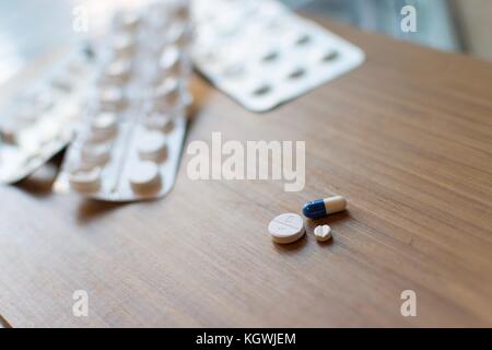 Medication tablets set out ready to be taken.  Blister pack tablet packaging  is in the background. Stock Photo