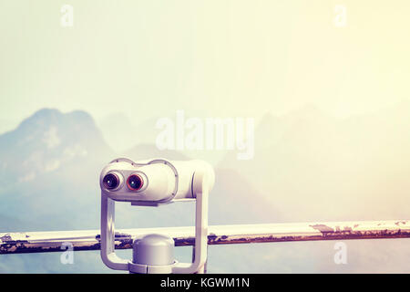 Vintage toned picture of tourist binoculars pointing at karst formations around Guilin. Selective focus. Stock Photo
