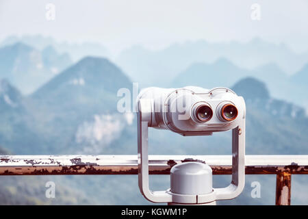 Vintage toned picture of tourist binoculars pointing at karst formations around Guilin. It is one of China most popular tourist destinations. Selectiv Stock Photo