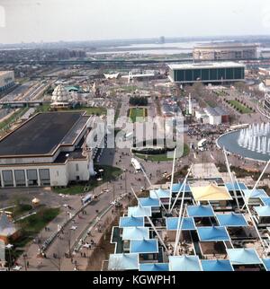 Panoramic aerial view facing north from the New York State Pavilion observation towers along the Avenue of The States, at the New York World's Fair in Flushing Meadows Park, Corona, Queens, New York, May, 1964. In the distance, LaGuardia Airport on the shore of Flushing Bay can be seen, with Shea Stadium to the right in the background. At upper right is the United States Pavilion building at the base of the Court of States. At center vertical is the New Amsterdam Plaza with the New York City Pavilion building to the left edge. At right are the hexagonal buildings of the New England States Pavi Stock Photo