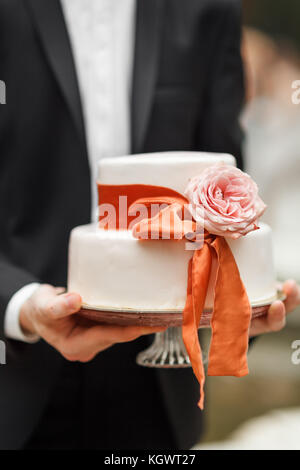 groom holding a wedding cake Stock Photo