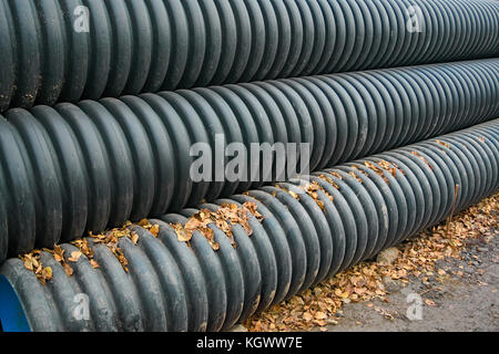 Pipes of PVC large diameter prepared for laying on construction site Stock Photo