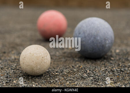 White Blue and Red Bocce Balls on gravel surface Stock Photo
