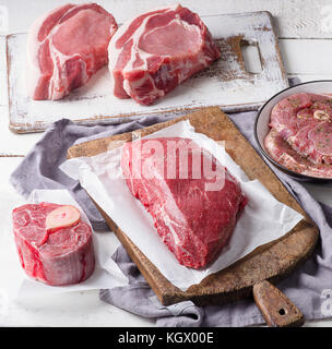 Different types of raw meat on a wooden table Stock Photo