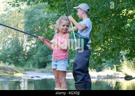 Happy kids fishing in river Stock Photo