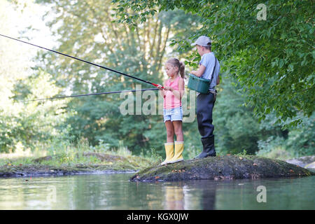 Happy kids fishing in river Stock Photo