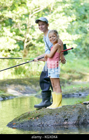 Happy kids fishing in river Stock Photo