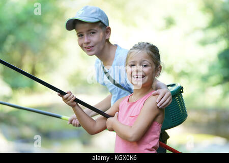 Happy kids fishing in river Stock Photo