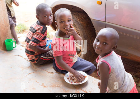 Smiling children sitting and eating porridge. Stock Photo