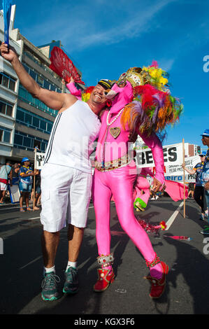 RIO DE JANEIRO - FEBRUARY 11, 2017: A figure in flamboyant pink costume celebrates at a street party during the city's carnival celebrations. Stock Photo