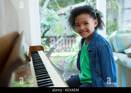 Adorable girl playing piano at home Stock Photo