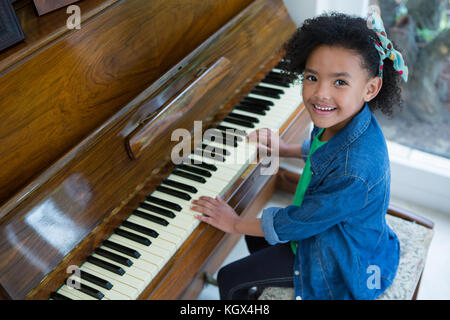 Adorable girl playing piano at home Stock Photo