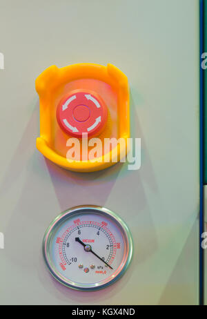 Emergency stop button and vacuum gage in machine Stock Photo