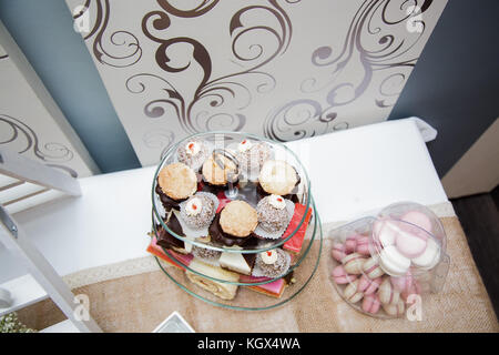 Photo of different cakes placed on a tree layered glass stand, view from above Stock Photo