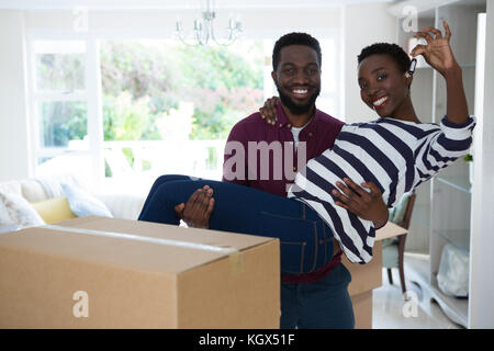 Portrait of man carrying woman while showing house key Stock Photo