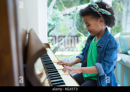 Adorable girl playing piano at home Stock Photo