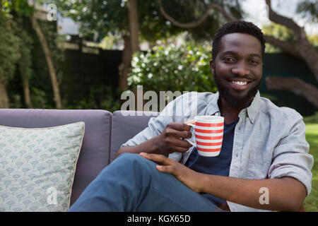 Happy man having black coffee in garden Stock Photo