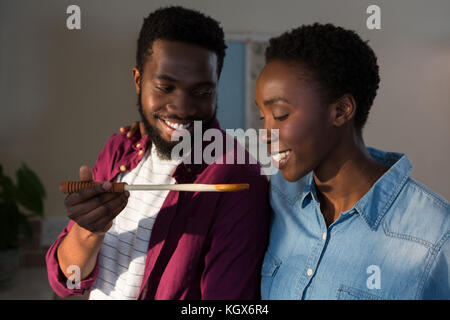 Happy couple tasting food in kitchen at home Stock Photo