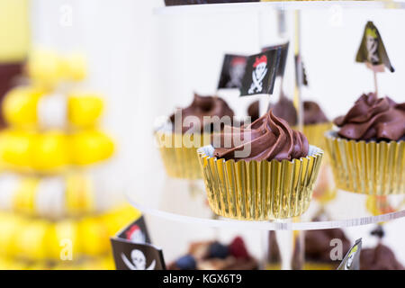 Close-up of cupcakes on stand in yellow and black colors, pirate theme for kids birthday party Stock Photo