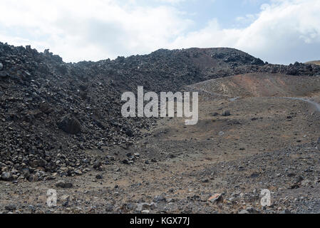 Exotic rocky road to the crater of the volcano. The volcano is located in the famous Caldera of Santorini. On a Sunny day. Stock Photo