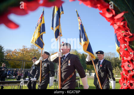 Royal British Legion standard bearers march past a wreath of poppies in the Royal Wootton Bassett Field of Remembrance at Lydiard park, Swindon, as it opens to honour and remember those who have been lost serving in the Armed Forces. Stock Photo