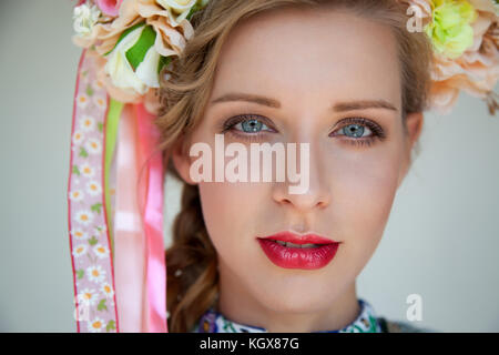Close-up portrait of young woman wearing traditional slovak folk dress and flower and ribbon headpiece