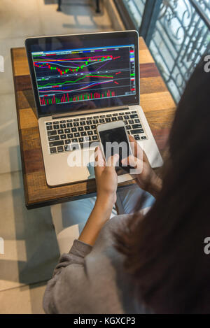 Stock trader using phone to buy shares Stock Photo