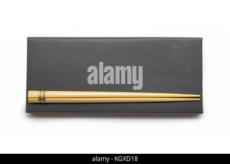 Wooden chopsticks on black box isolated on white background Stock Photo