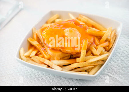 Francesinha - a Portuguese sandwich served with french fries, originally from Porto, Portugal Stock Photo