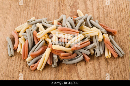 Colorful strozzapreti italian pasta on wood background Stock Photo