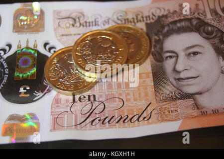 Queen Elizabeth on Ten one pound coin coins £ note money cash stirling financial new plastic design and 12 sided coin. stock photo, stock photograph, Stock Photo
