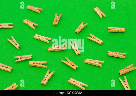 Set of wooden clothespins on bright green background Stock Photo