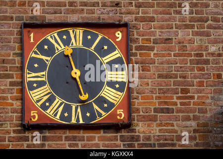 Ancient golden tower clock on a red brickwalll, Stro church, Denmark, November 6, 2017 Stock Photo