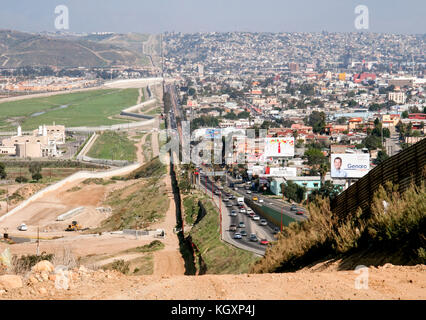 US-Mexico international border between Tijuana, Mexico (right) and San Diego, California (left) separated by a corrugated iron fence made from repurposed landing mats after the Vietnam war. See more information below. Stock Photo