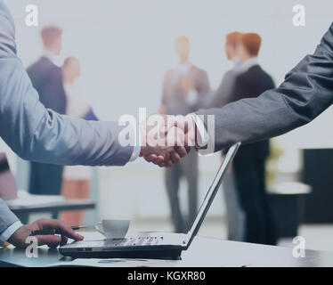 Confident business handshake. Close-up view of a handshake. business office in formal wear and work at a laptop Stock Photo